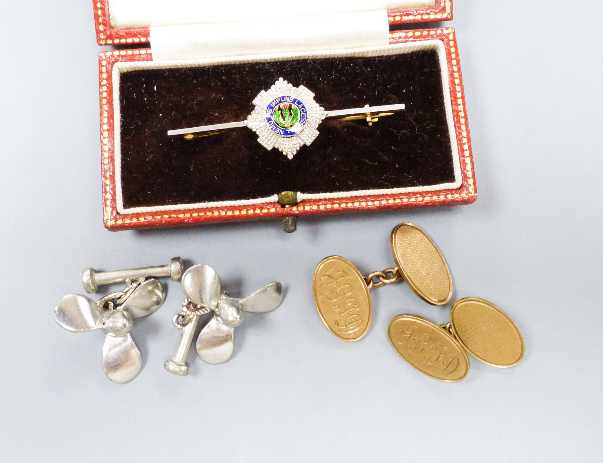 A pair of 9ct gold oval cufflinks with engraved monogram, 11.5 grams, a 14ct, plat and enamel 'Order of the Thistle' bar brooch, 47mm gross 5.1 grams and a pair of base metal propeller cufflinks.